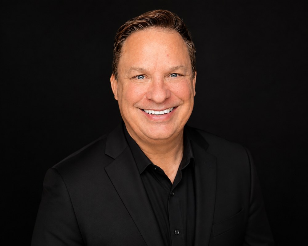Studio portrait of Mark Krajnik, founder of Performance Mindset Associates, in a black jacket